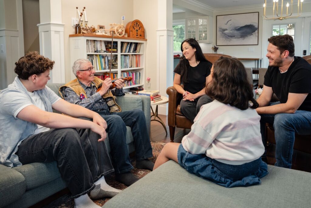 A diverse family shares laughter and stories while spending quality time together in a cozy living room.