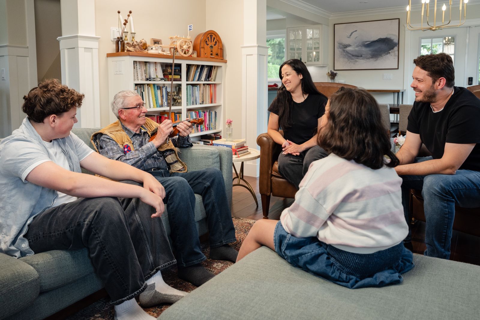 A diverse family shares laughter and stories while spending quality time together in a cozy living room.