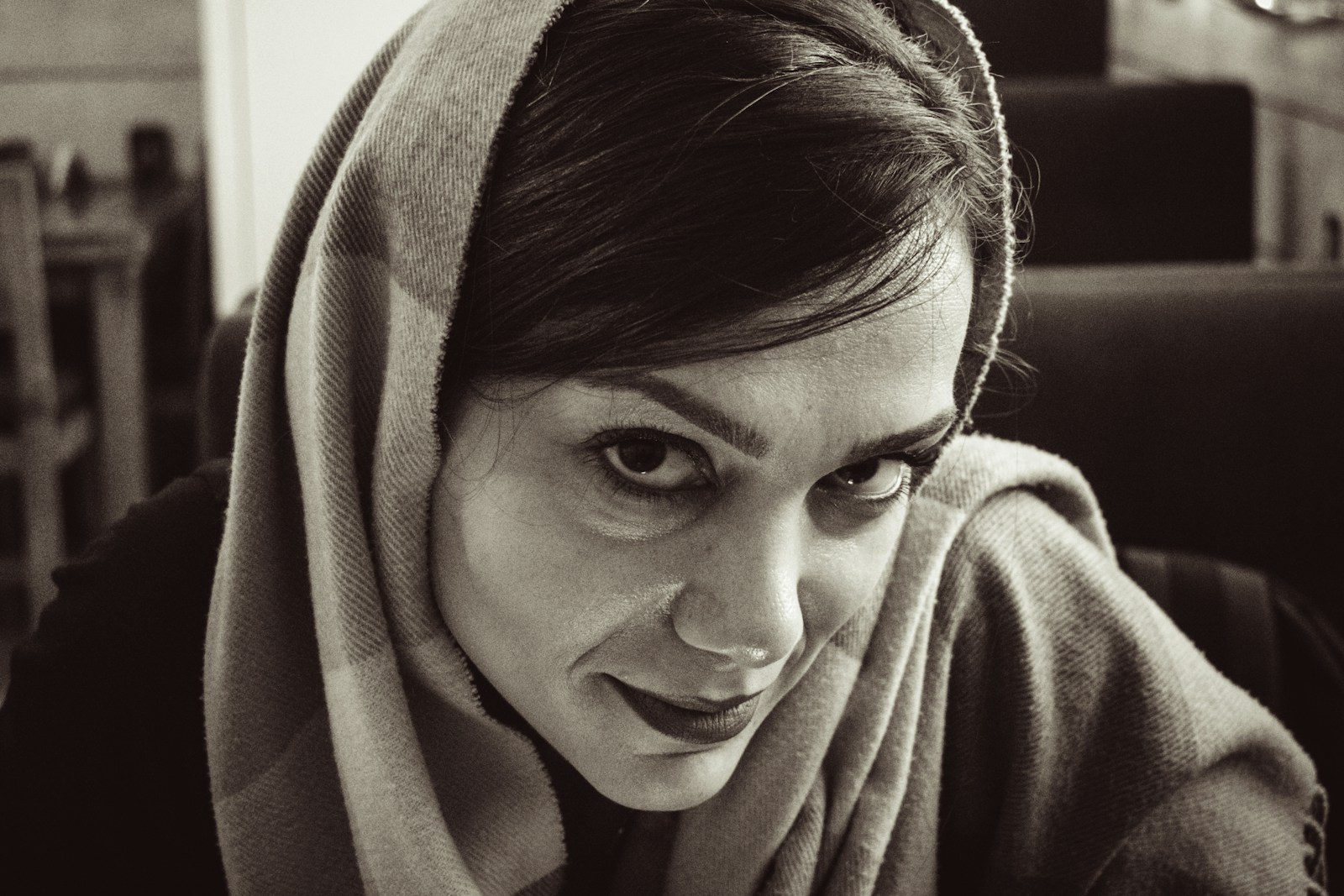 A woman wearing a headscarf looks towards the camera.
