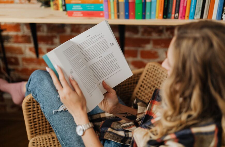 A woman sitting comfortably indoors enjoying her book in a cozy and peaceful setting.