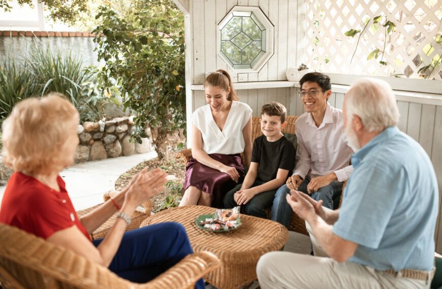 A diverse family enjoys a cheerful gathering in a cozy patio setting.