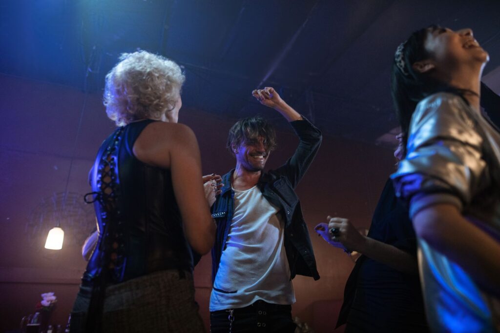 Lively indoor party with adults dancing under club lights, capturing nightlife excitement.