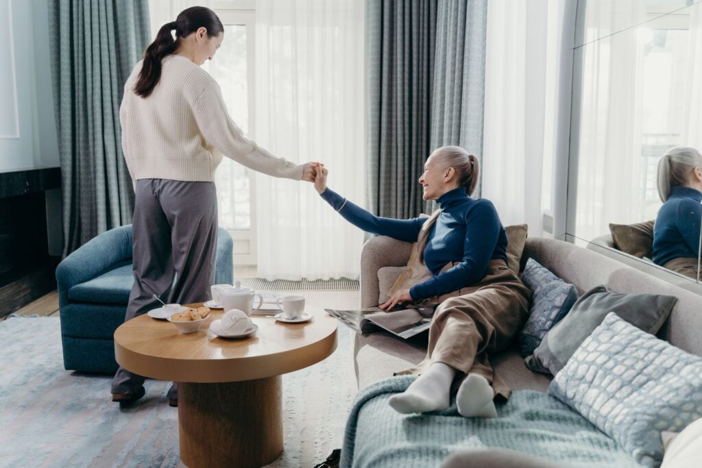 A senior woman and her adult daughter enjoy quality time relaxing at home.