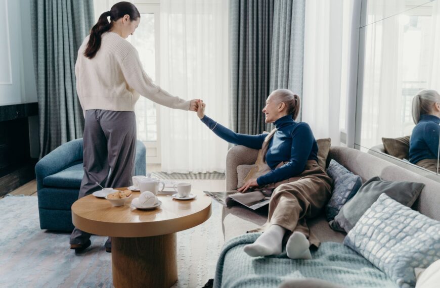 A senior woman and her adult daughter enjoy quality time relaxing at home.