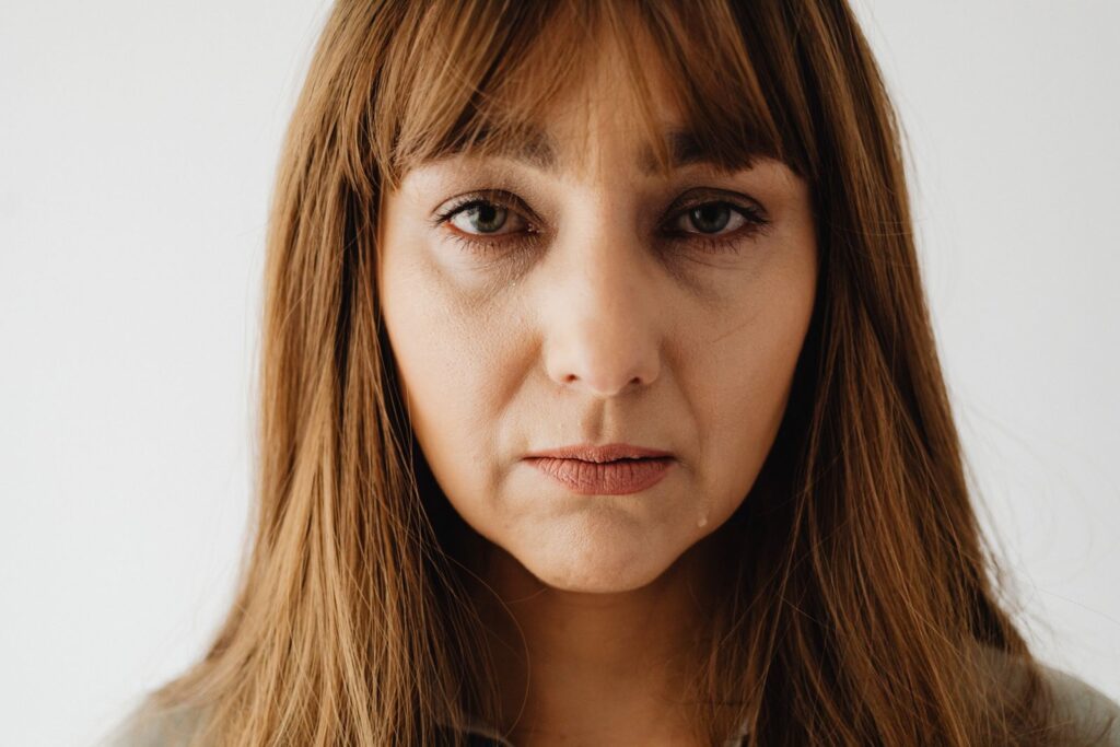 Portrait of a sad caucasian woman with tears in her eyes, reflecting emotion and introspection.