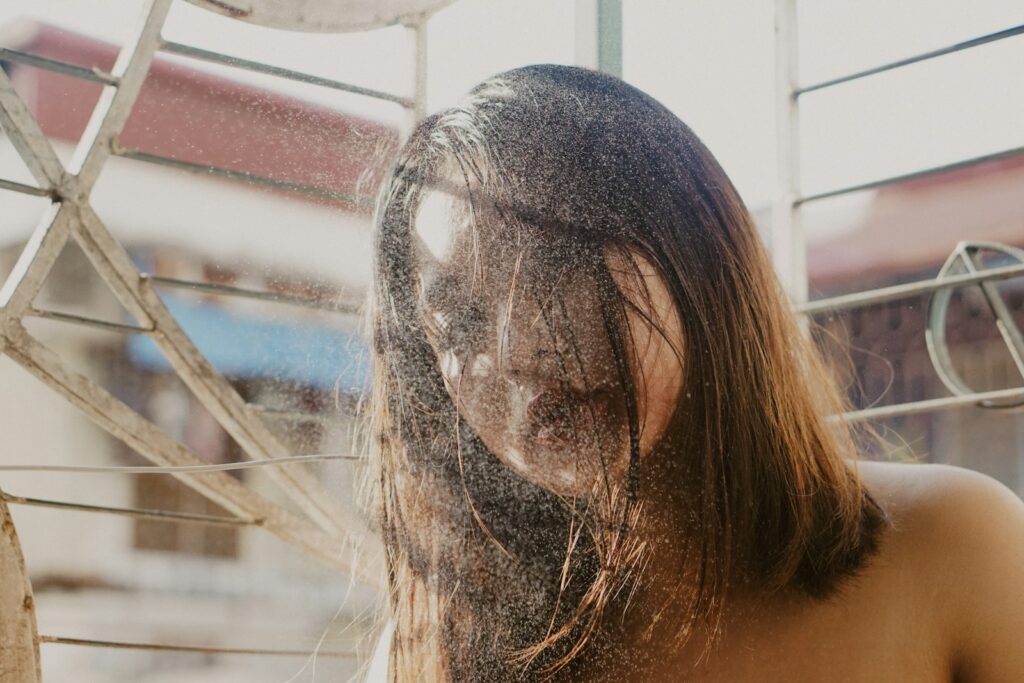 topless woman covering face with hair