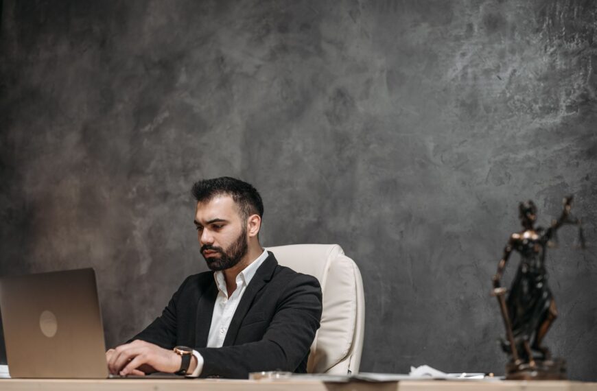 Focused professional man in an office environment working on a laptop.