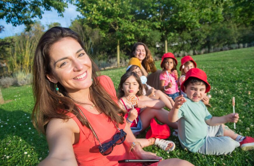 Smiling group enjoying a sunny day taking a selfie on grass in Portugal.