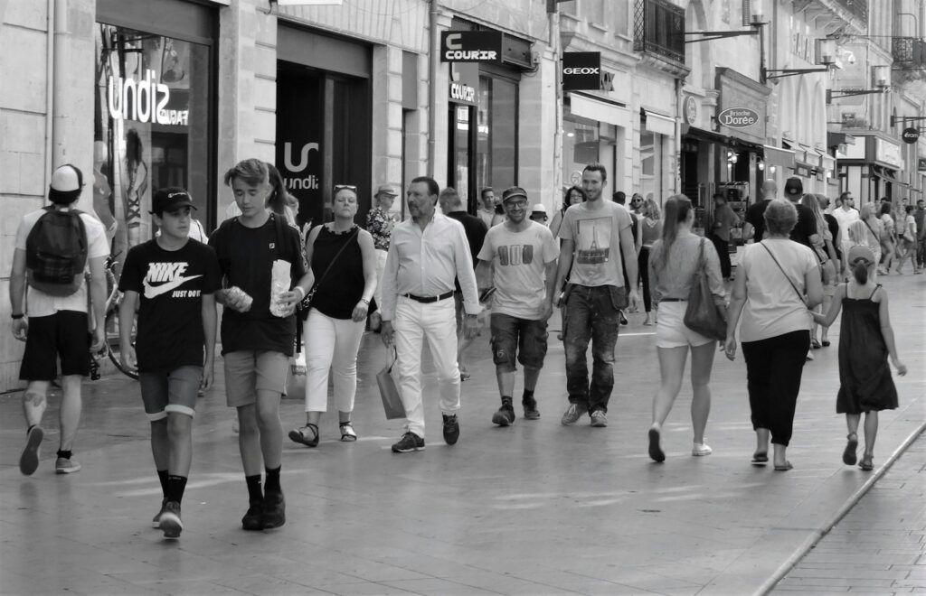 People walking on a busy street in black and white.