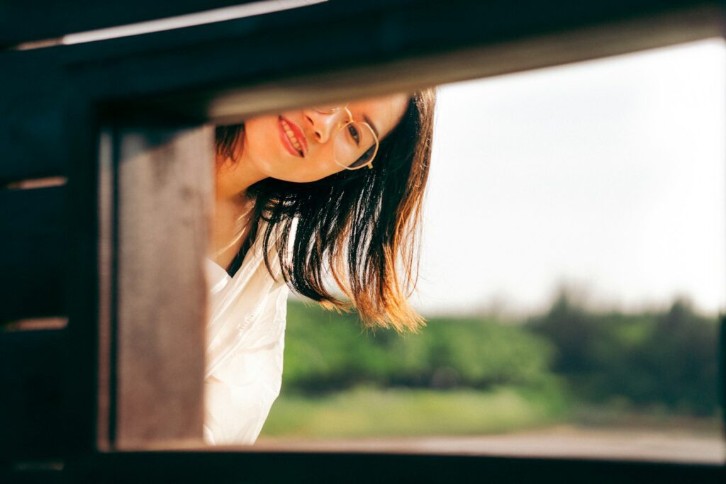 a woman is looking out of a window