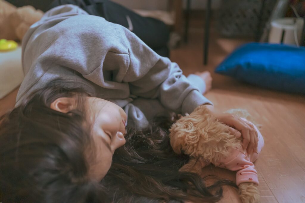 girl in gray sweater lying on brown textile
