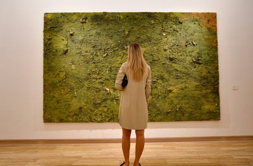 Woman observing a large abstract green painting
