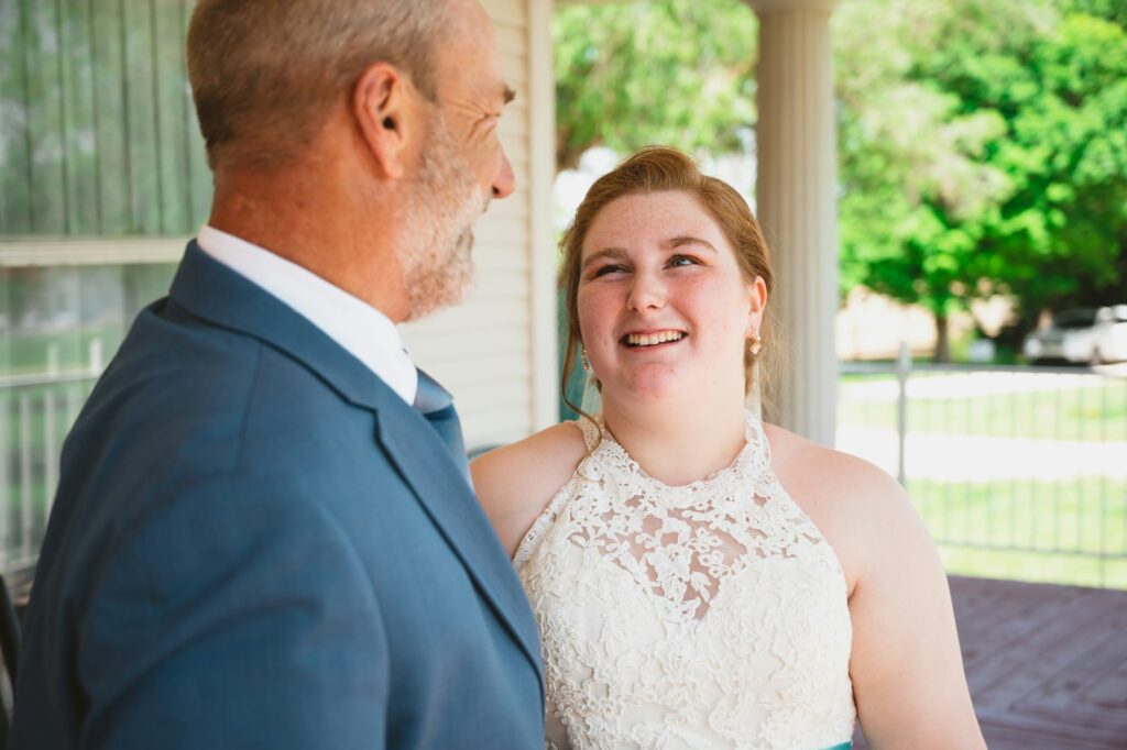 a woman in a white dress standing next to a man in a blue suit