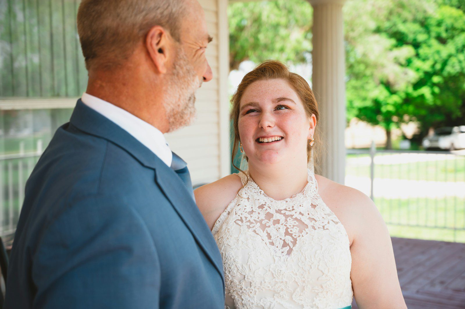 a woman in a white dress standing next to a man in a blue suit