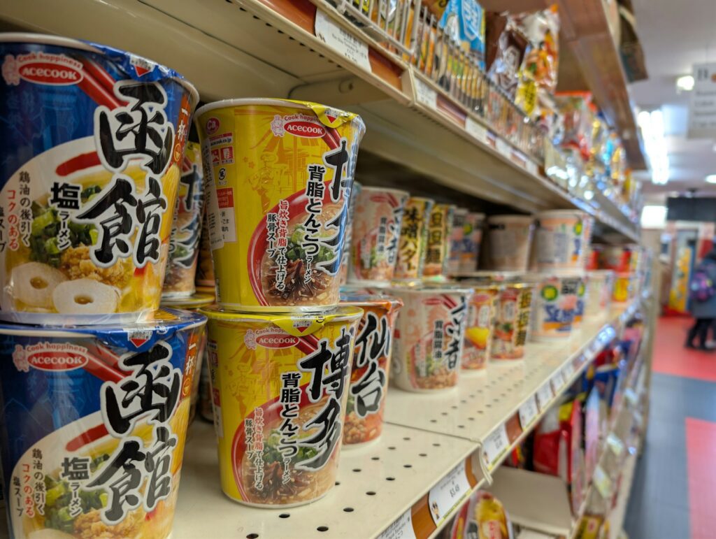 Shelves stocked with various instant noodle cups.