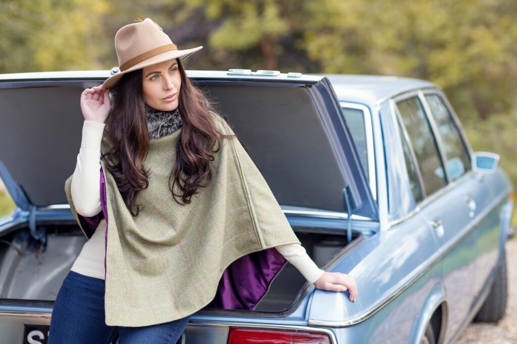 a woman leaning on the trunk of a car