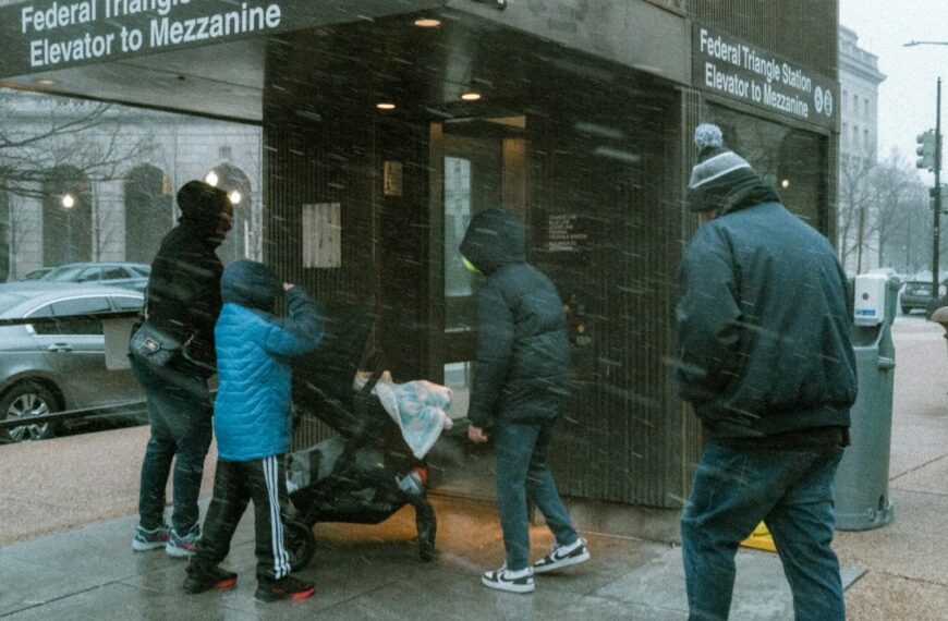 People gather near an elevator entrance during snowfall.