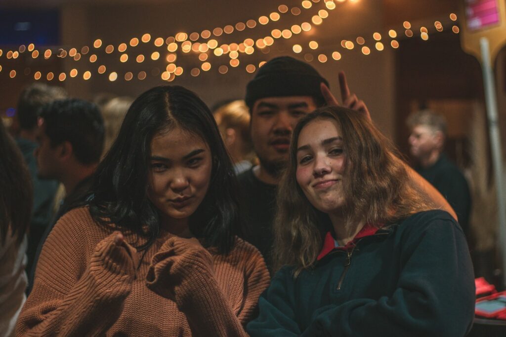 two women and man taking selfie