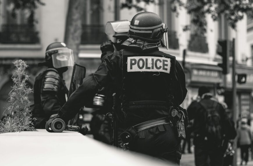 grayscale photo of Police standing and leaning on wall