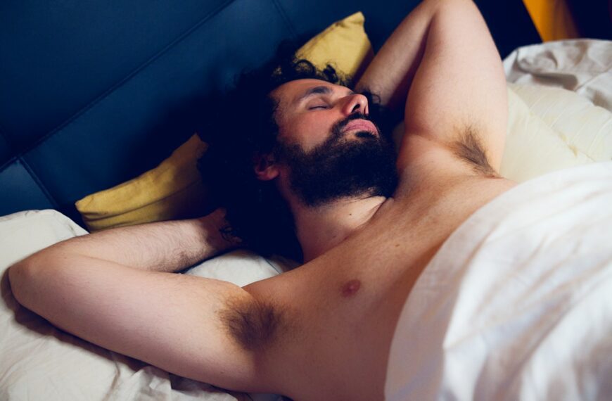 topless man lying on bed