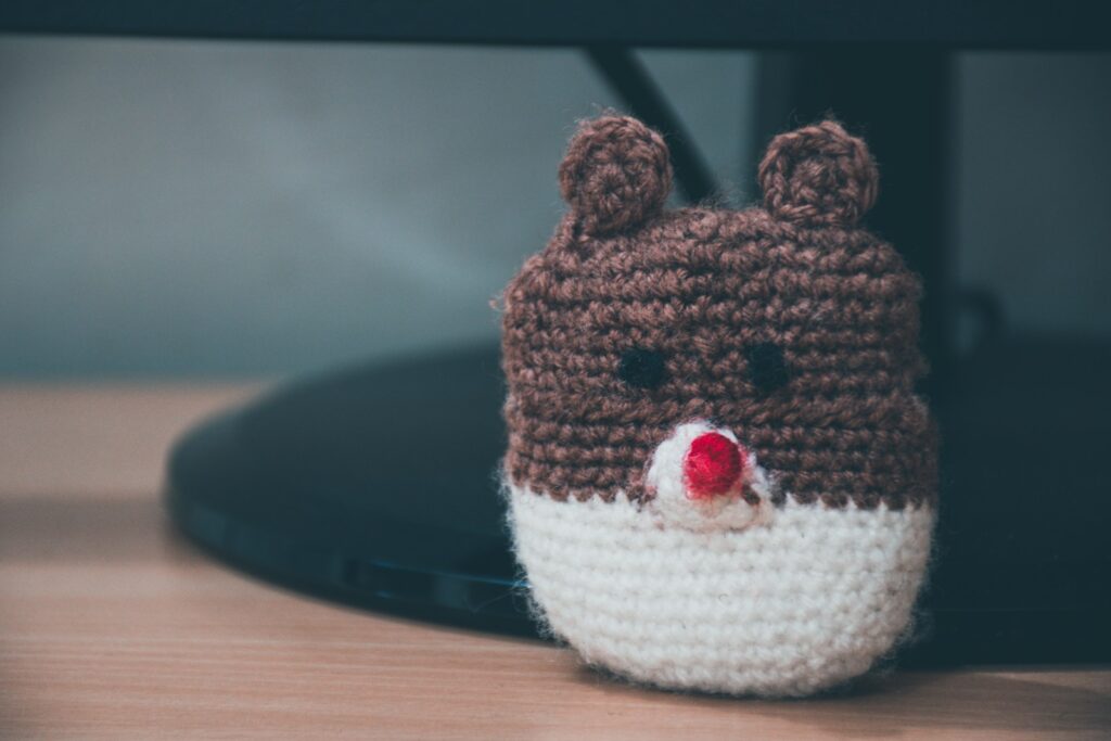 brown and white knitted owl on brown wooden table