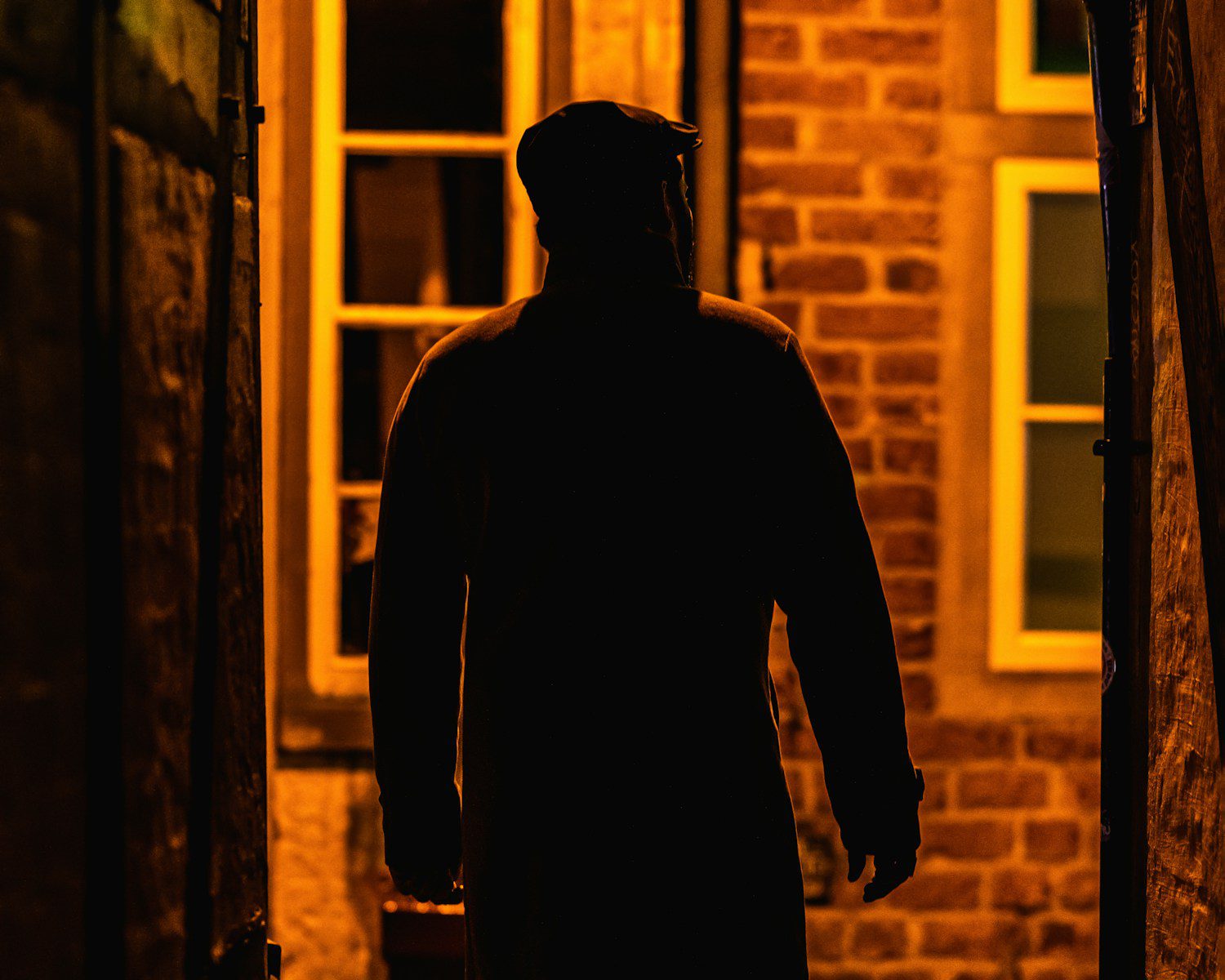 A man walking down a dark alley way