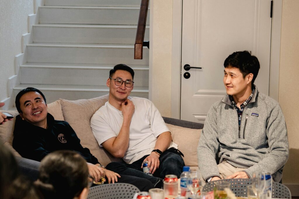 Three men sitting on a couch talking