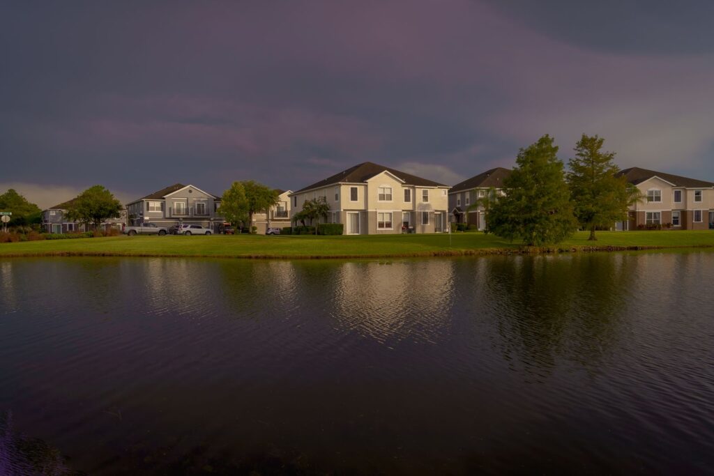 Scenic view of lakefront homes reflecting on water under a dramatic sky in Orlando.