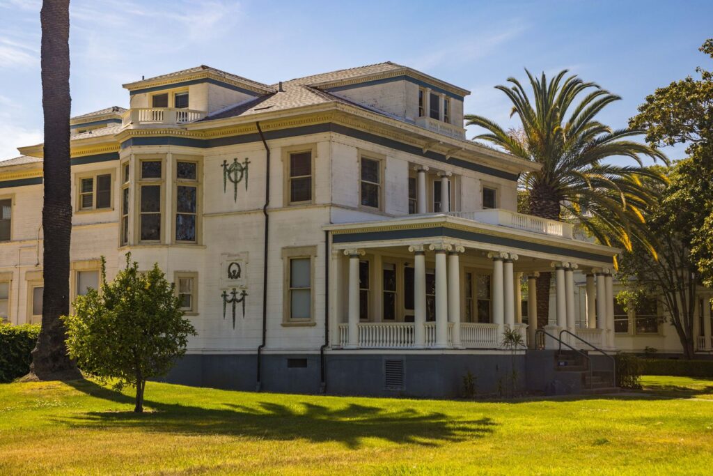 Elegant colonial mansion with classic columns in a sunny outdoor setting.