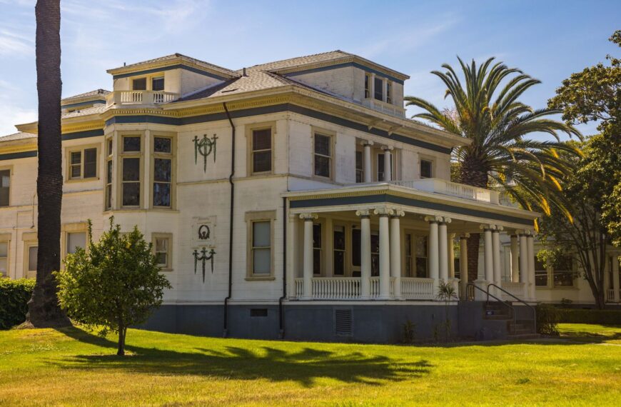 Elegant colonial mansion with classic columns in a sunny outdoor setting.