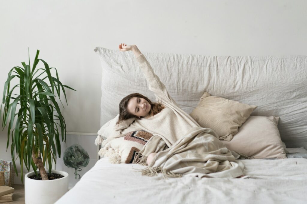 a woman laying on a bed with a blanket