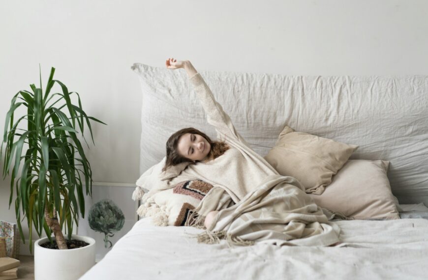 a woman laying on a bed with a blanket