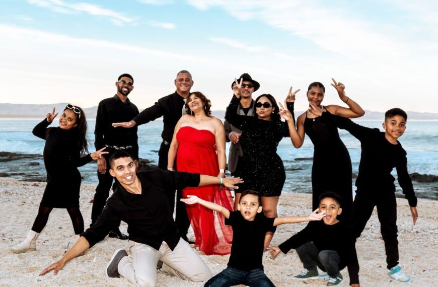 A cheerful family enjoying a fun photo moment on a Cape Town beach.