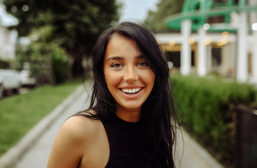 Captivating portrait of a cheerful young woman outdoors in Tbilisi, showcasing natural beauty.