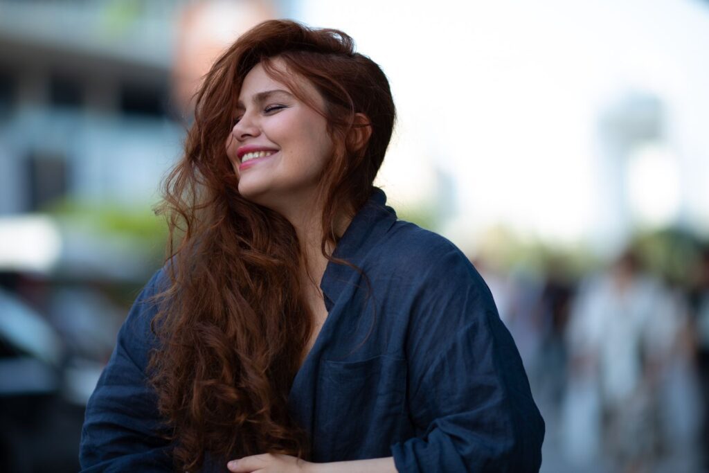 Portrait of a woman joyfully smiling outdoors in Baku city, capturing a candid and warm moment.