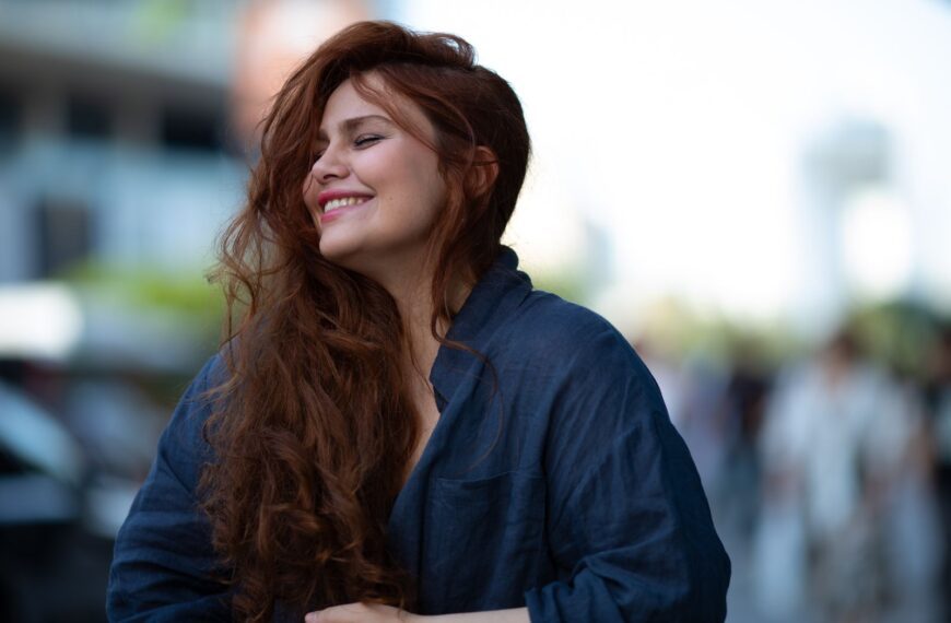Portrait of a woman joyfully smiling outdoors in Baku city, capturing a candid and warm moment.