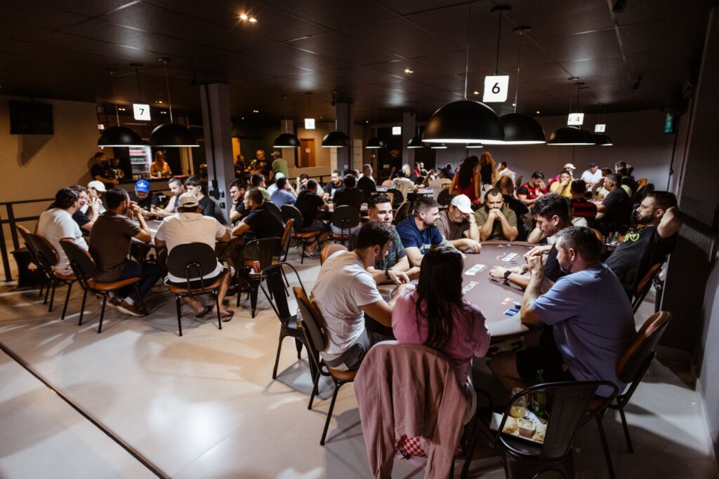 Intense poker game in a lively casino with multiple players. Experience the thrill and strategy of poker.