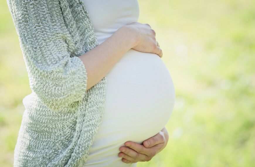 a pregnant woman holding her belly in her hands