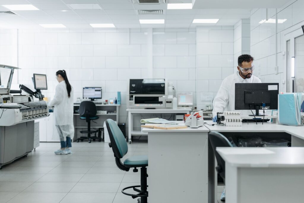 Researchers in protective gear conduct experiments in a high-tech lab environment.