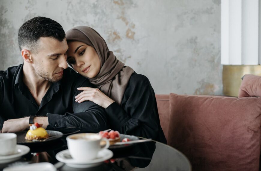 A loving Muslim couple sitting together in a cozy café setting, enjoying a serene moment.