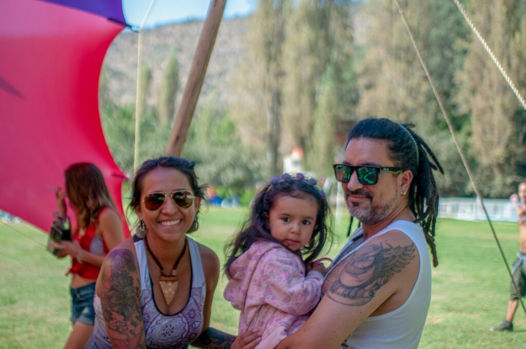 man carrying toddler girl beside smiling woman under canopy