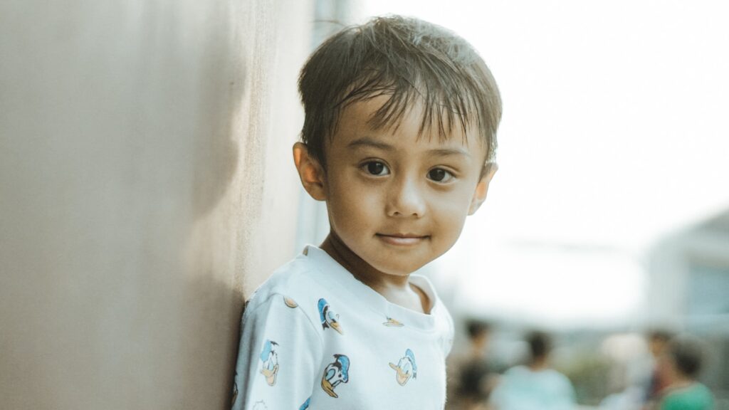 A happy child smiles at the camera.