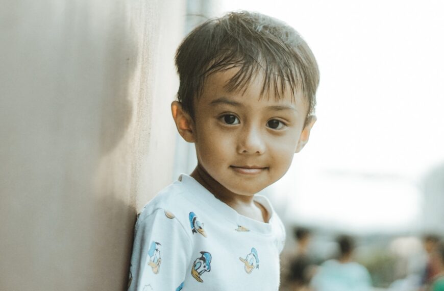 A happy child smiles at the camera.
