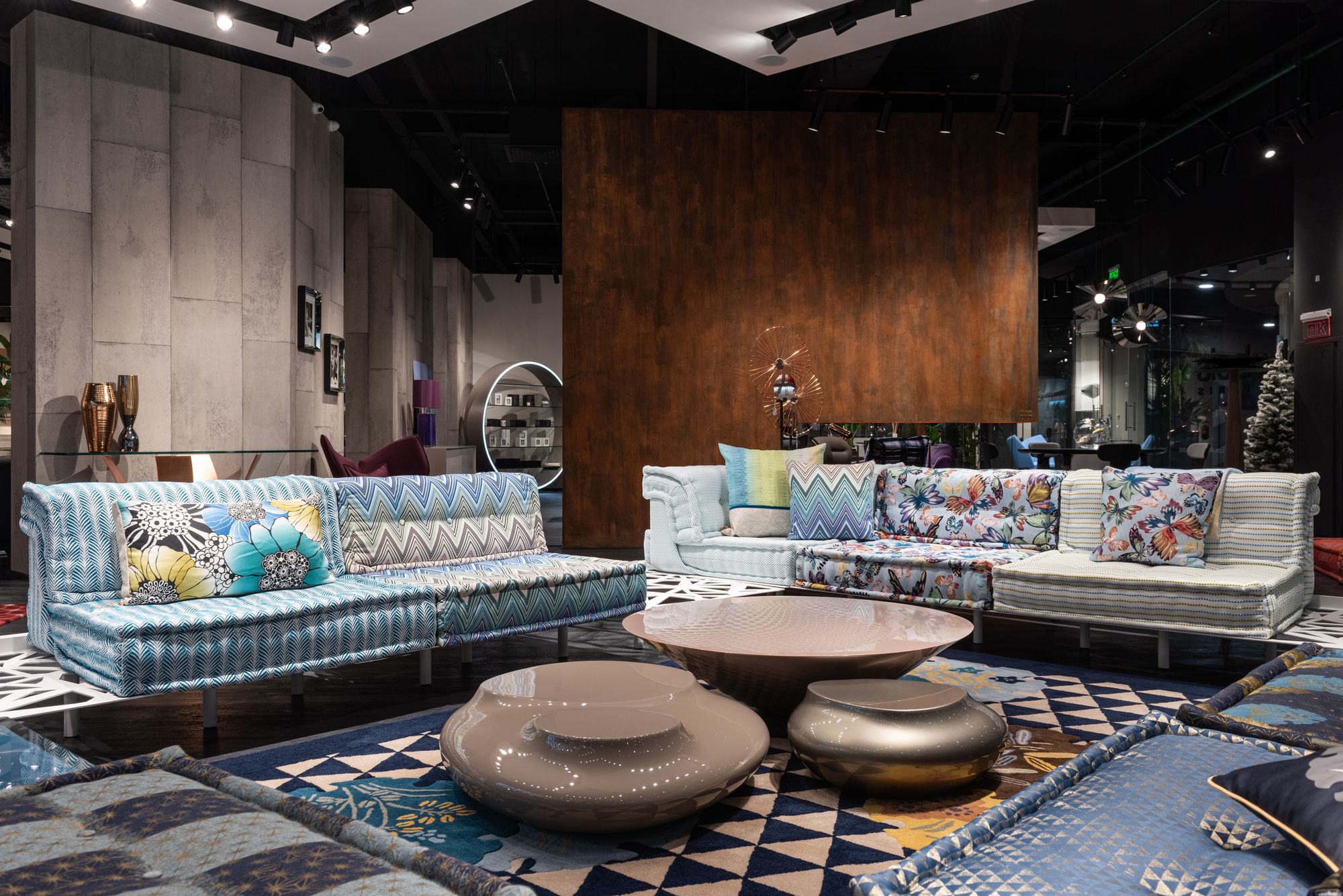 Modern furniture showroom displaying sofas and coffee tables on a patterned rug