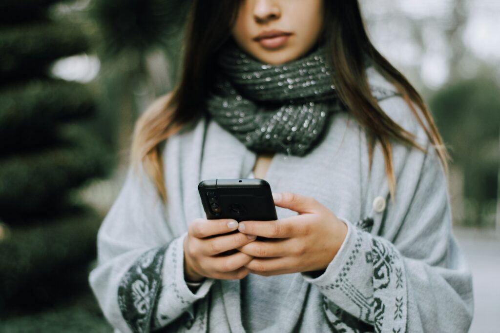 Young woman holding a smartphone outdoors