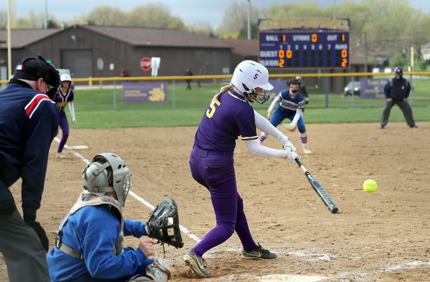 a person hitting a ball with a baseball bat