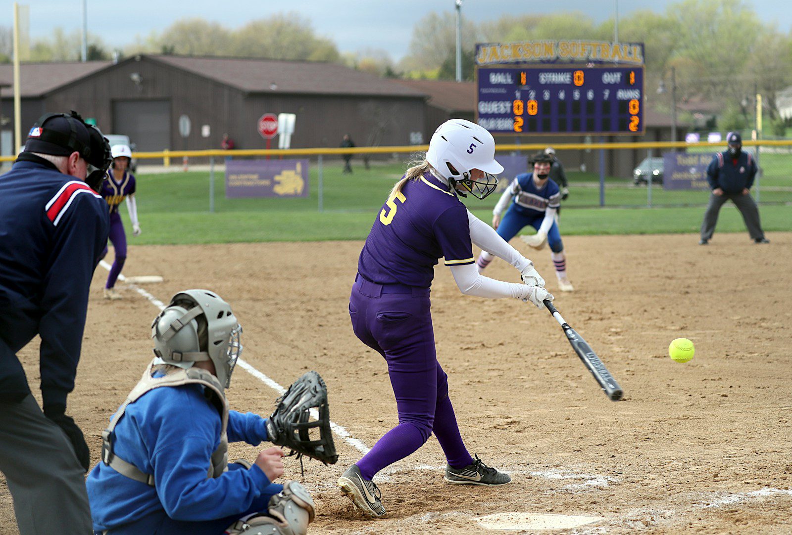 a person hitting a ball with a baseball bat