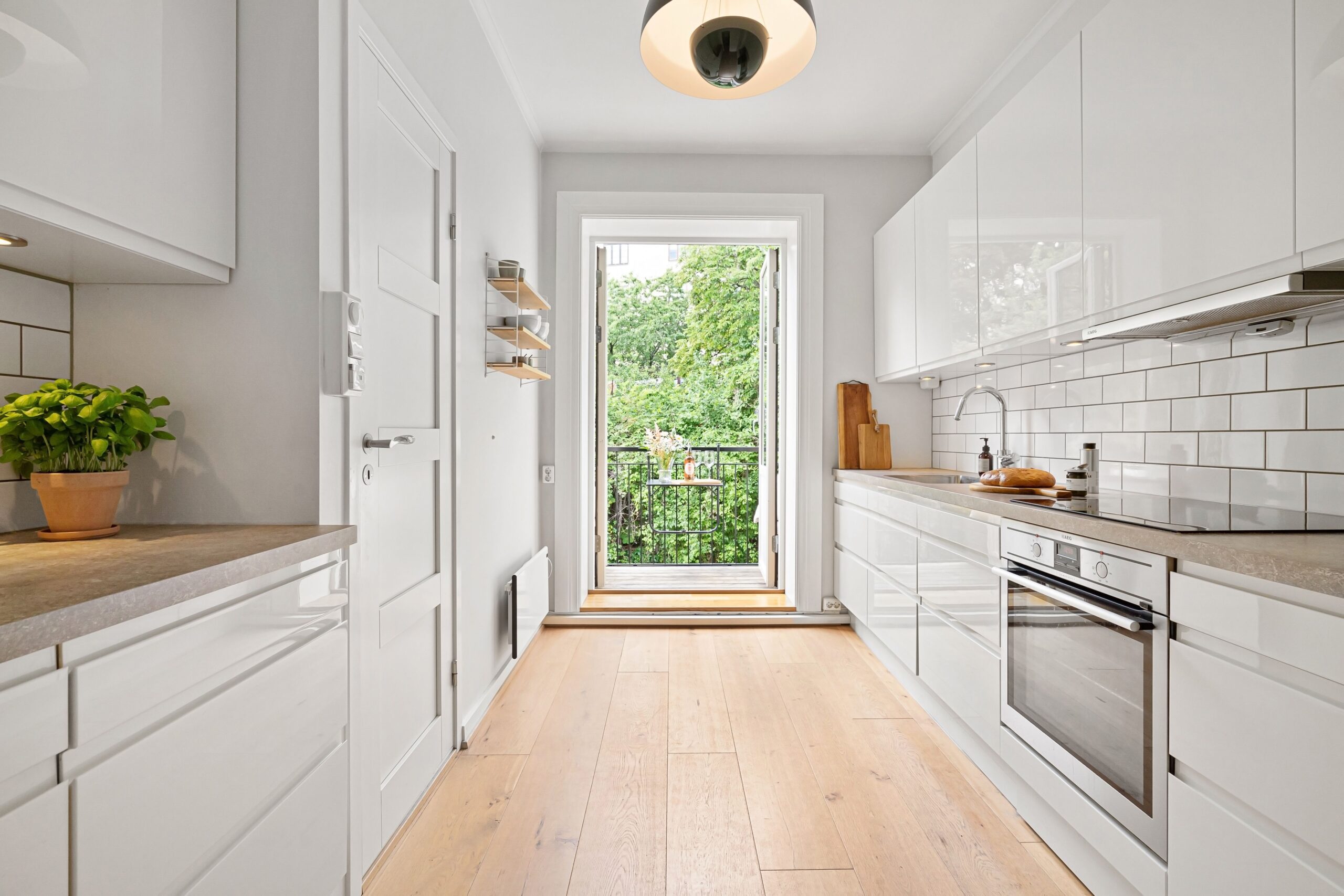 Sleek modern kitchen with white cabinets and balcony access