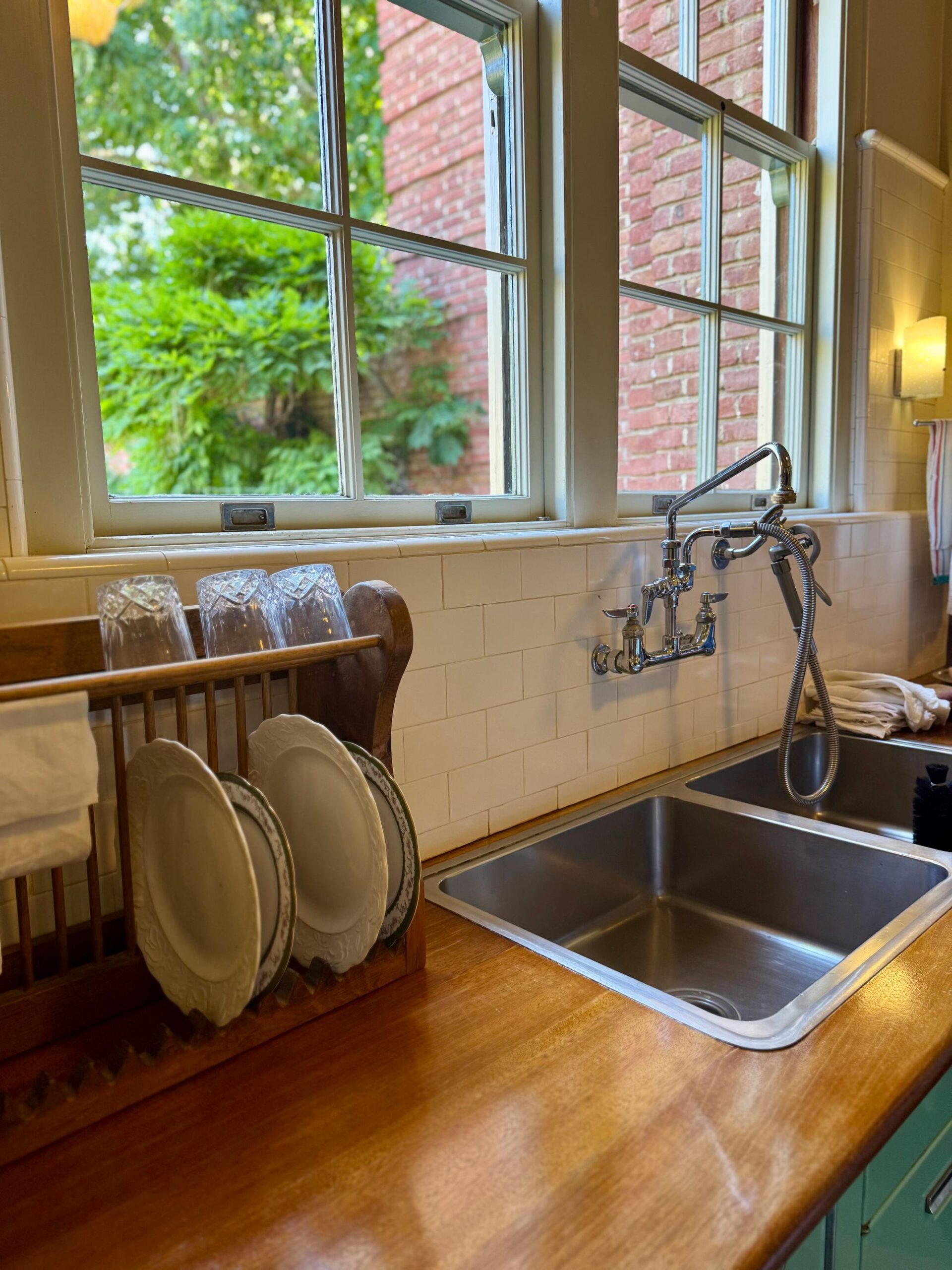 Cozy kitchen sink with dishes beside a sunlit window, illustrating where household germs collect