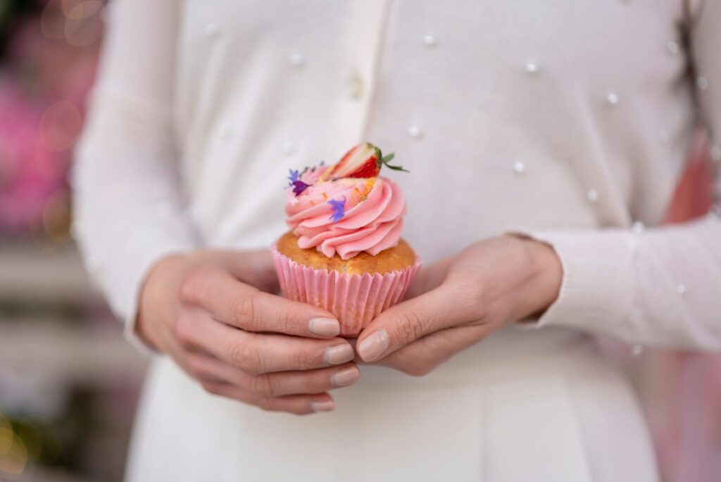a woman holding a cupcake in her hands
